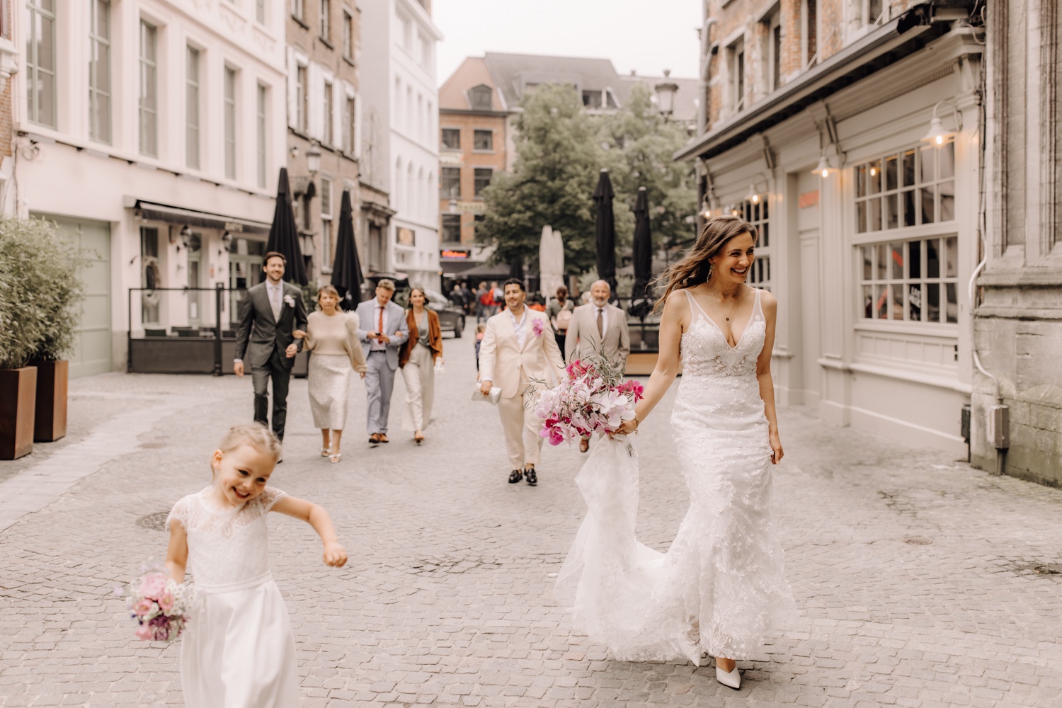 Huwelijksfotograaf Antwerpen - suite wandelt samen naar het stadhuis van Antwerpen met de bruid voorop