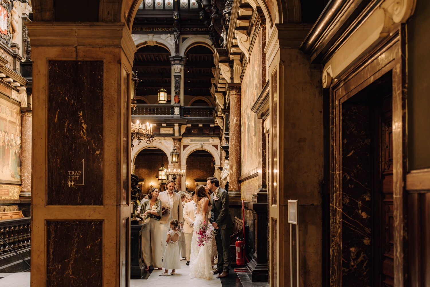 Huwelijksfotograaf Antwerpen - bruidspaar kust elkaar in de grote hal van het Antwerpse stadhuis