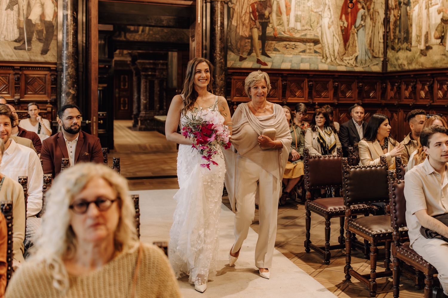 Huwelijksfotograaf Antwerpen - bruid wandelt het gangpad in samen met haar moeder