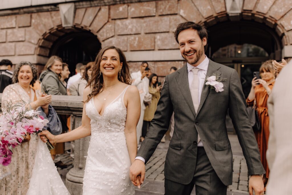 Huwelijksfotograaf Antwerpen - Bruidspaar wandelt het stadhuis van Antwerpen uit