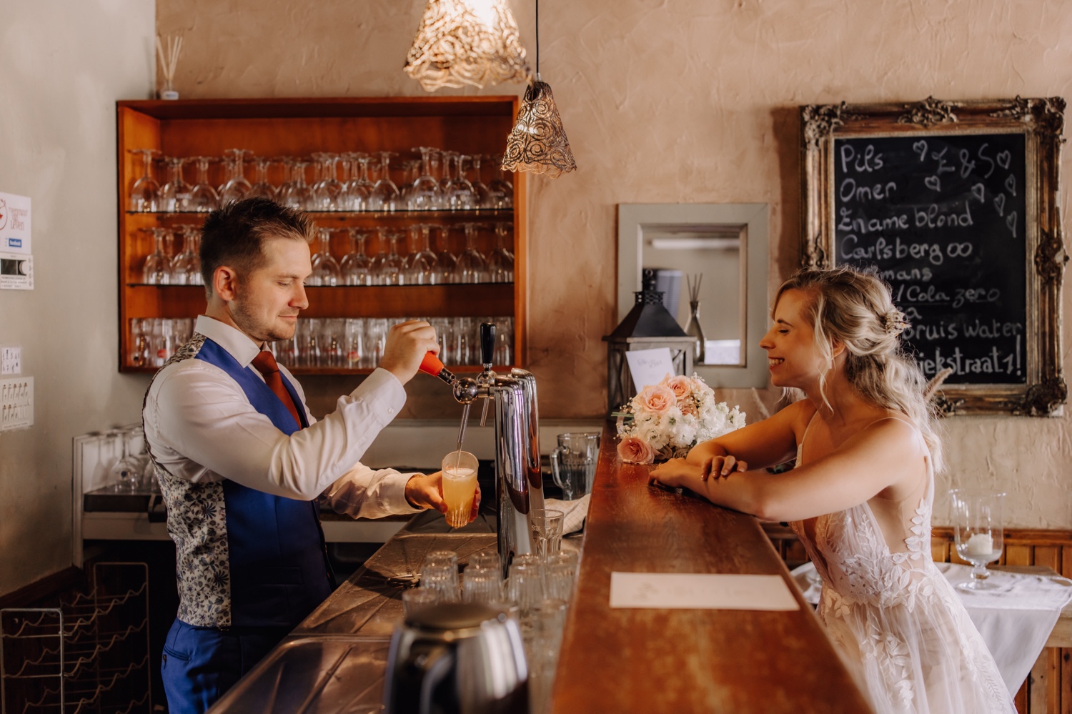 Zomers huwelijk op unieke landelijke locatie in Horebeke - bruidegom tapt een pintje voor zijn bruid in het café van 'T verstand van leven te Horebeke