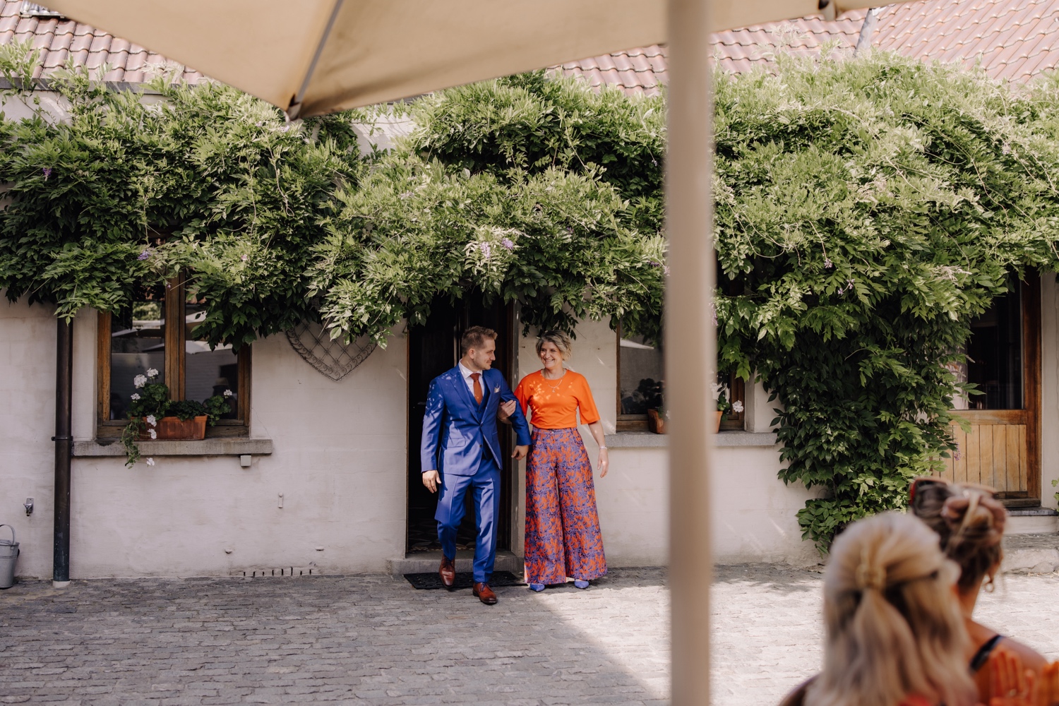 Zomers huwelijk op unieke landelijke locatie in Horebeke - bruidegom wandelt met zijn mama naar voor tijdens ceremonie