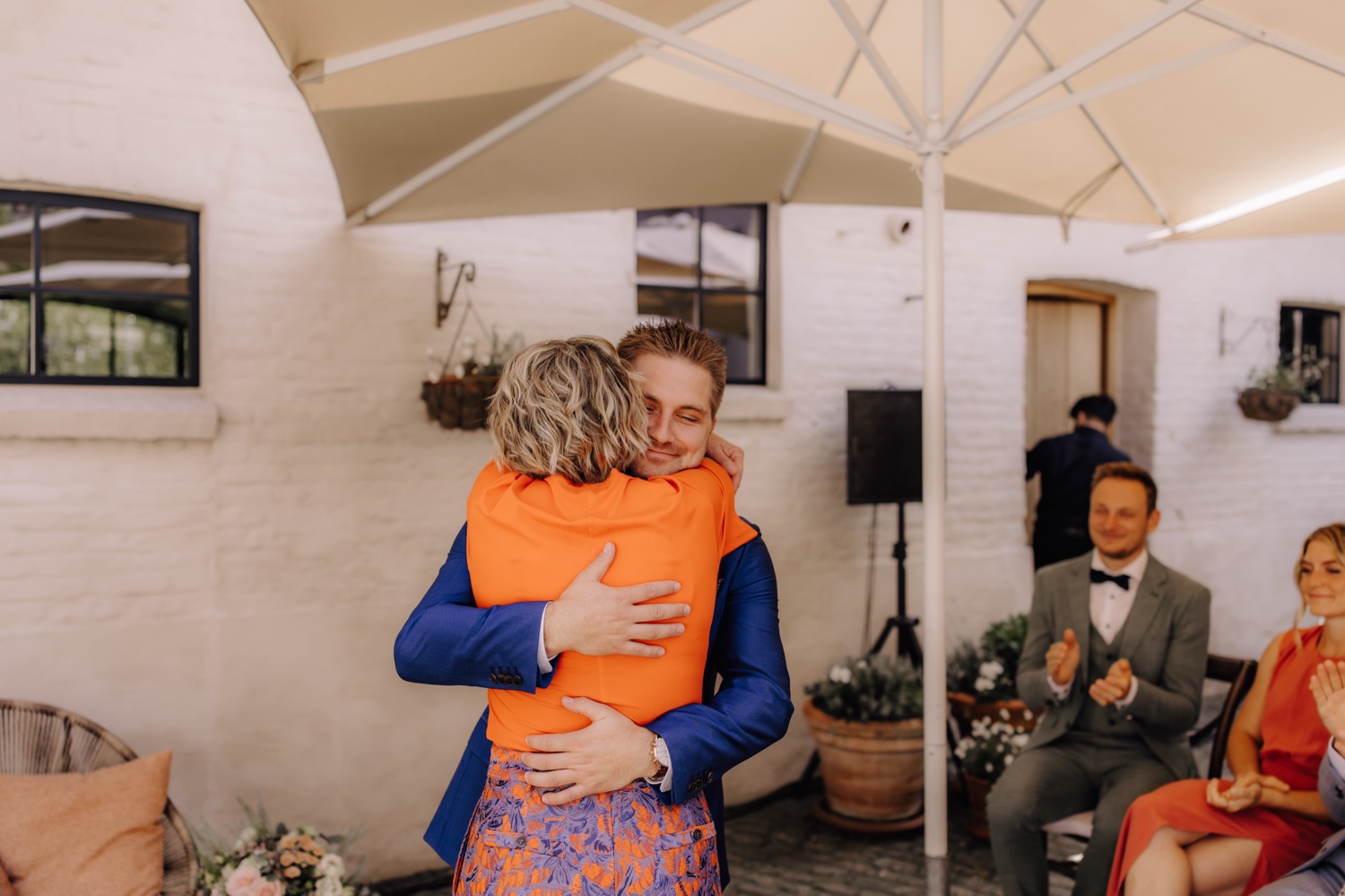 Zomers huwelijk op unieke landelijke locatie in Horebeke - bruidegom en zijn mama omhelzen elkaar bij de ceremonie