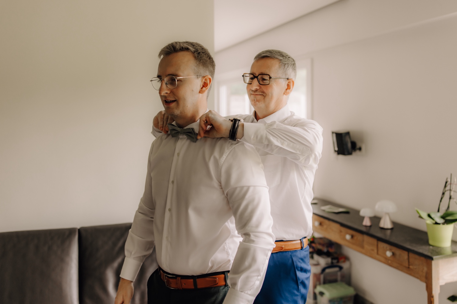 Landelijk huwelijk bij vierkantshoeve Bar Silo - vader van de bruidegom helpt zijn zoon met zijn strik