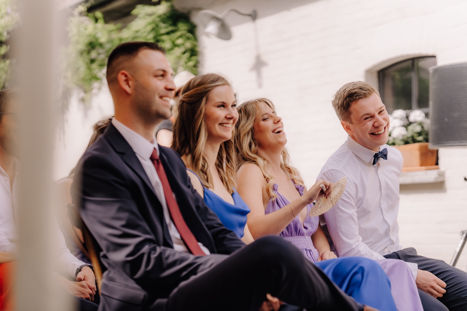 Zomers huwelijk op unieke landelijke locatie in Horebeke - gasten lachen tijdens ceremonie