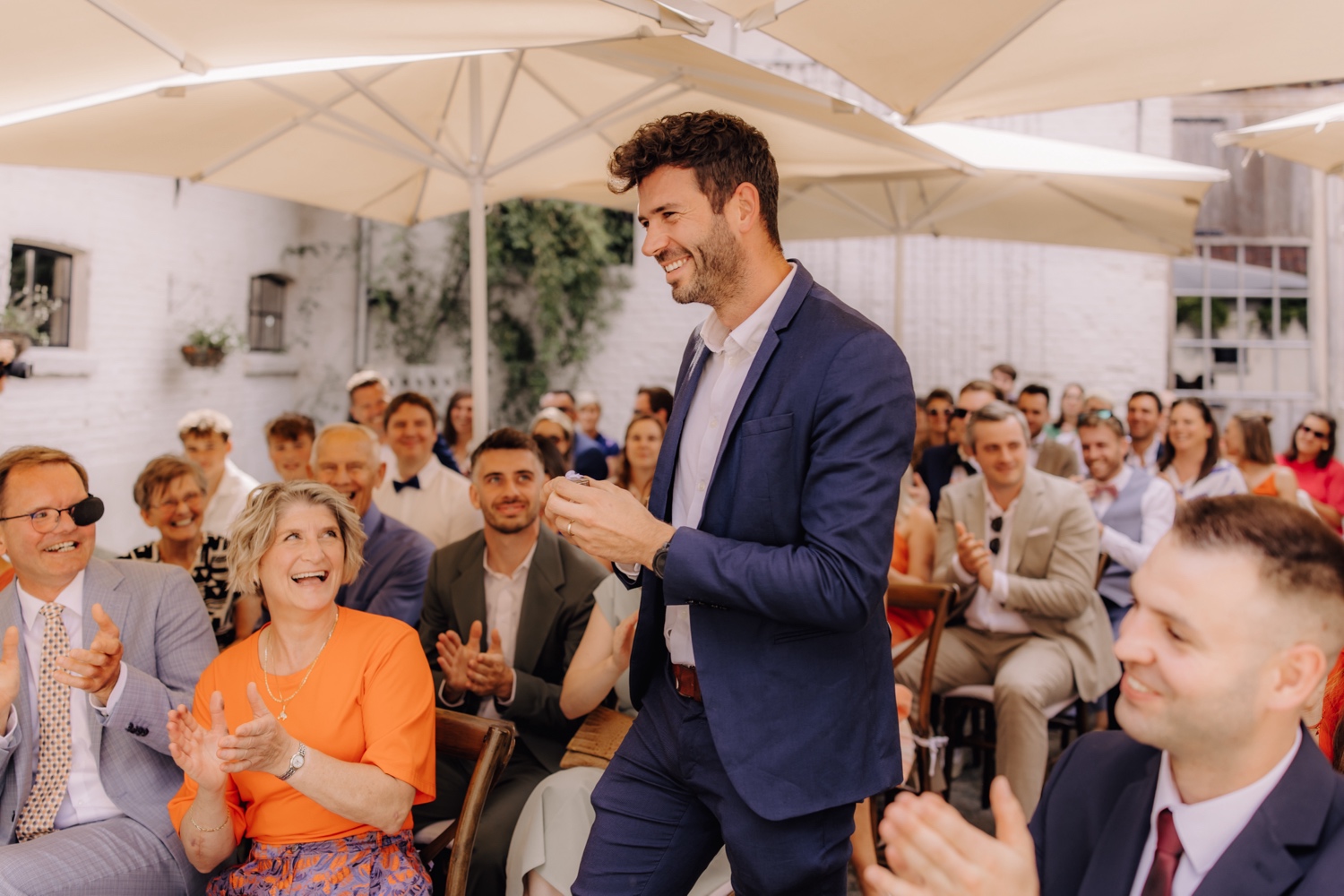 Zomers huwelijk op unieke landelijke locatie in Horebeke - gast wandelt met de ringen naar voor tijdens ceremonie