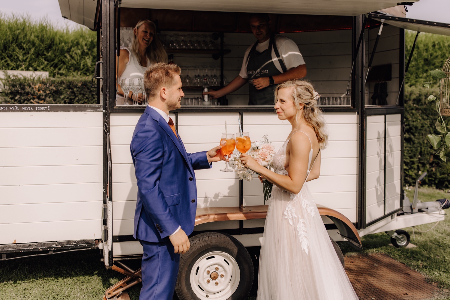 Zomers huwelijk op unieke landelijke locatie in Horebeke - bruidspaar klinkt met een groot glas aperol spritz