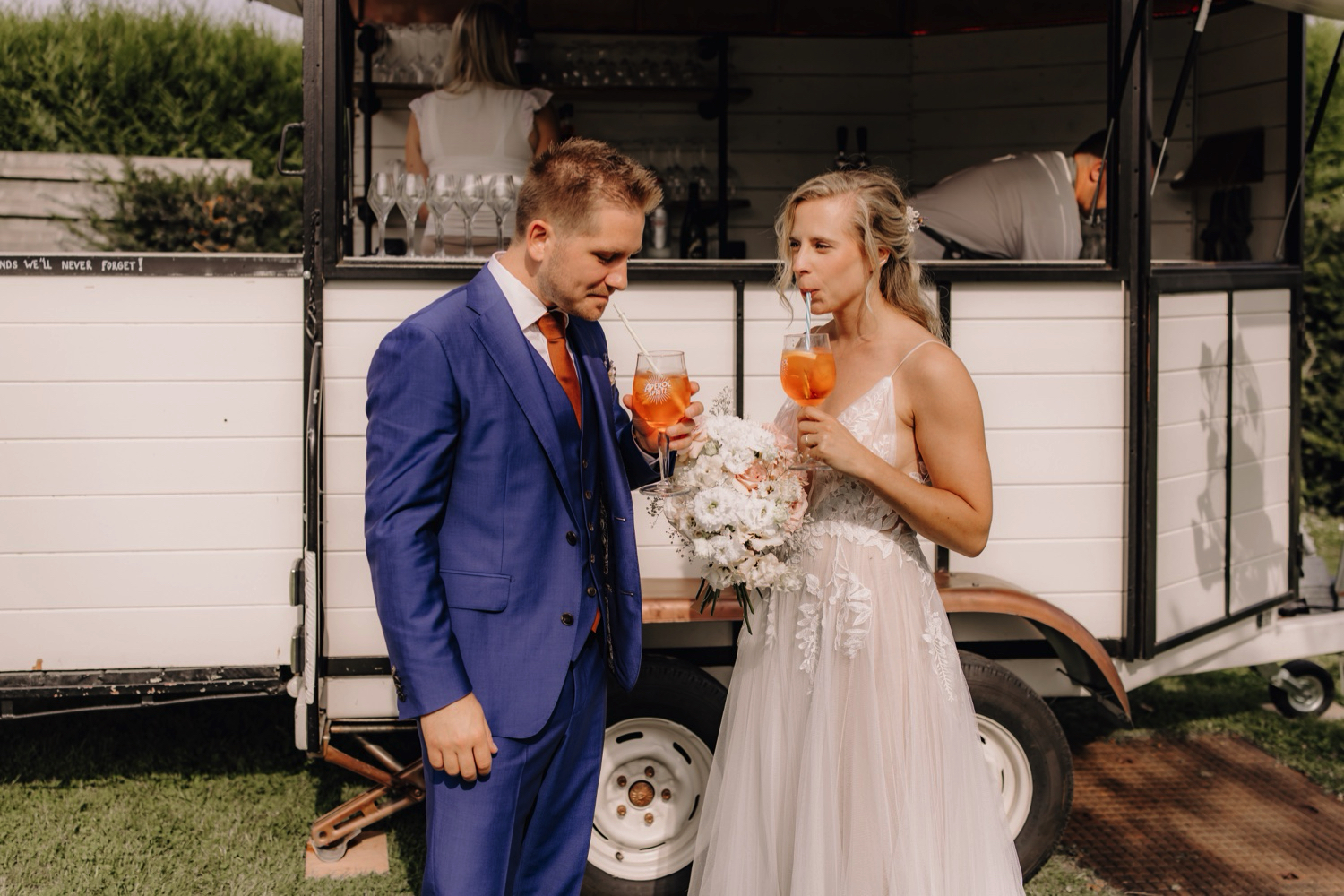 Zomers huwelijk op unieke landelijke locatie in Horebeke - bruid en bruidegom nemen een slokje van hun aperol spritz