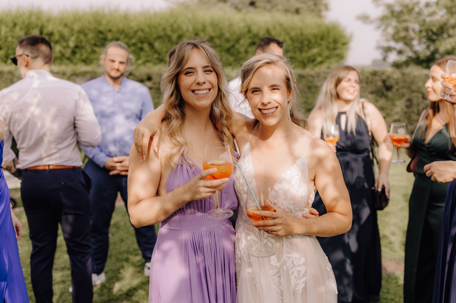 Zomers huwelijk op unieke landelijke locatie in Horebeke - bruid poseert met haar tweelingzus voor de foto