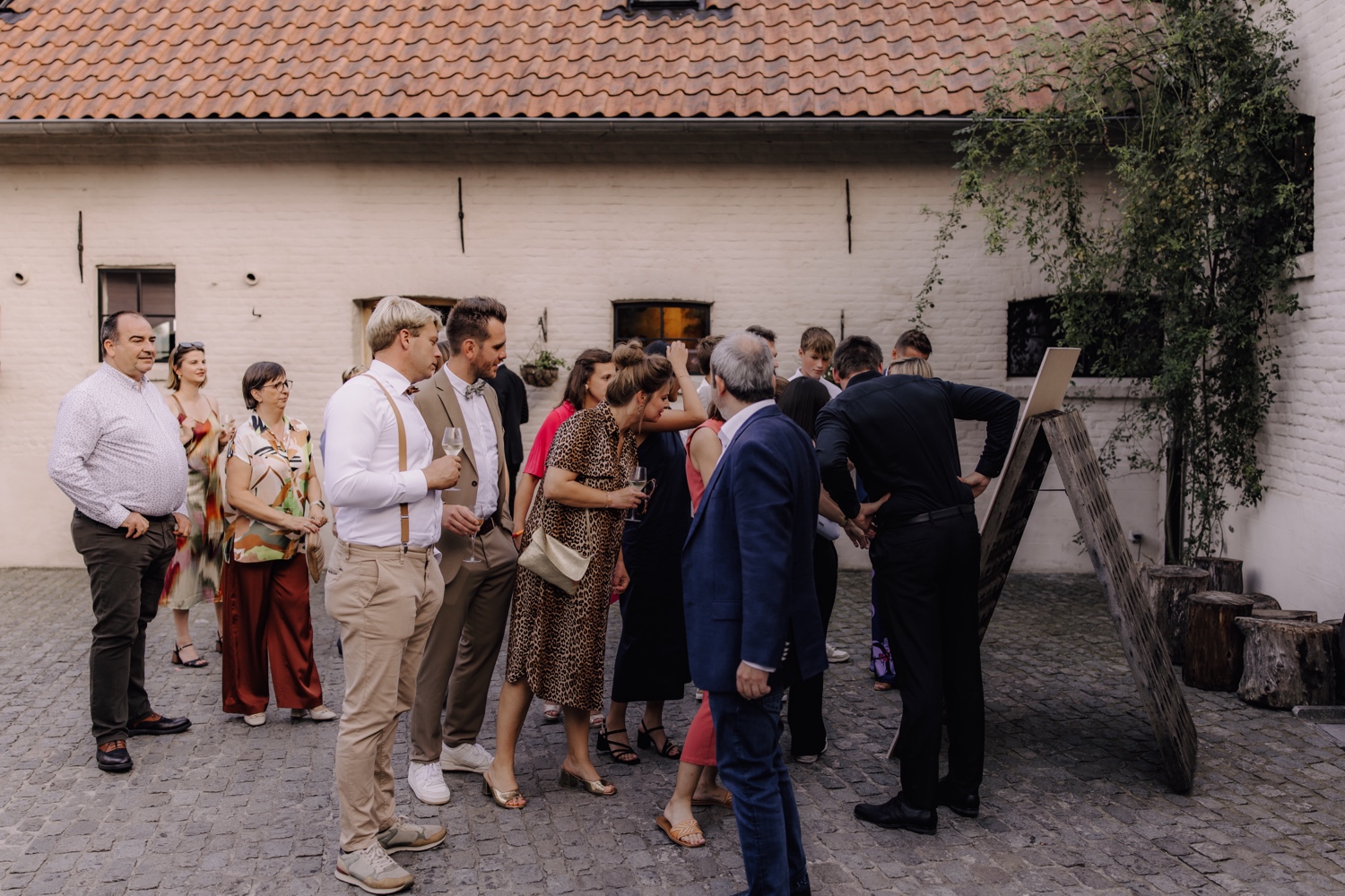 Zomers huwelijk op unieke landelijke locatie in Horebeke - gasten zoeken op het bord uit aan welke tafel ze zitten