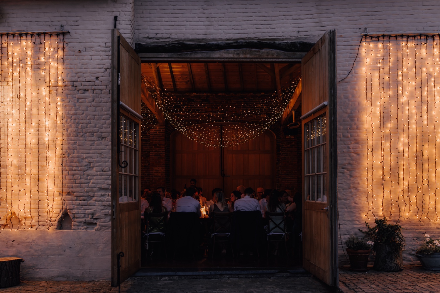 Zomers huwelijk op unieke landelijke locatie in Horebeke - sfeerfoto van het diner in de schuur