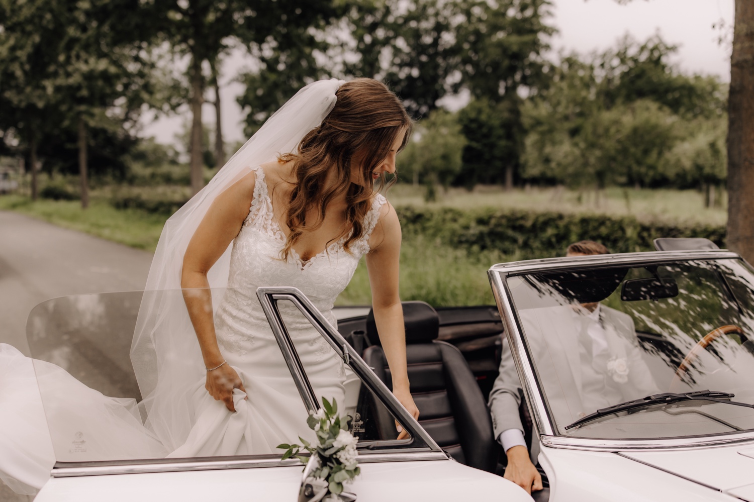 Intiem huwelijk bij La Butte Aux Bois - bruid stapt in een witte oldtimer bruidswagen