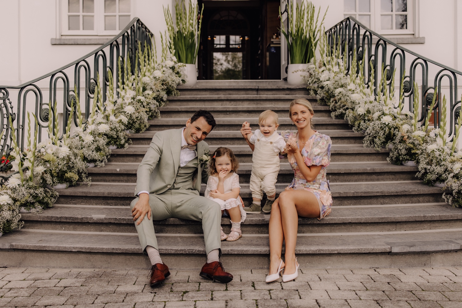 Huwelijksreceptie in het Sint-Michielskasteel - bruidspaar poseert met hun kinderen op de trappen