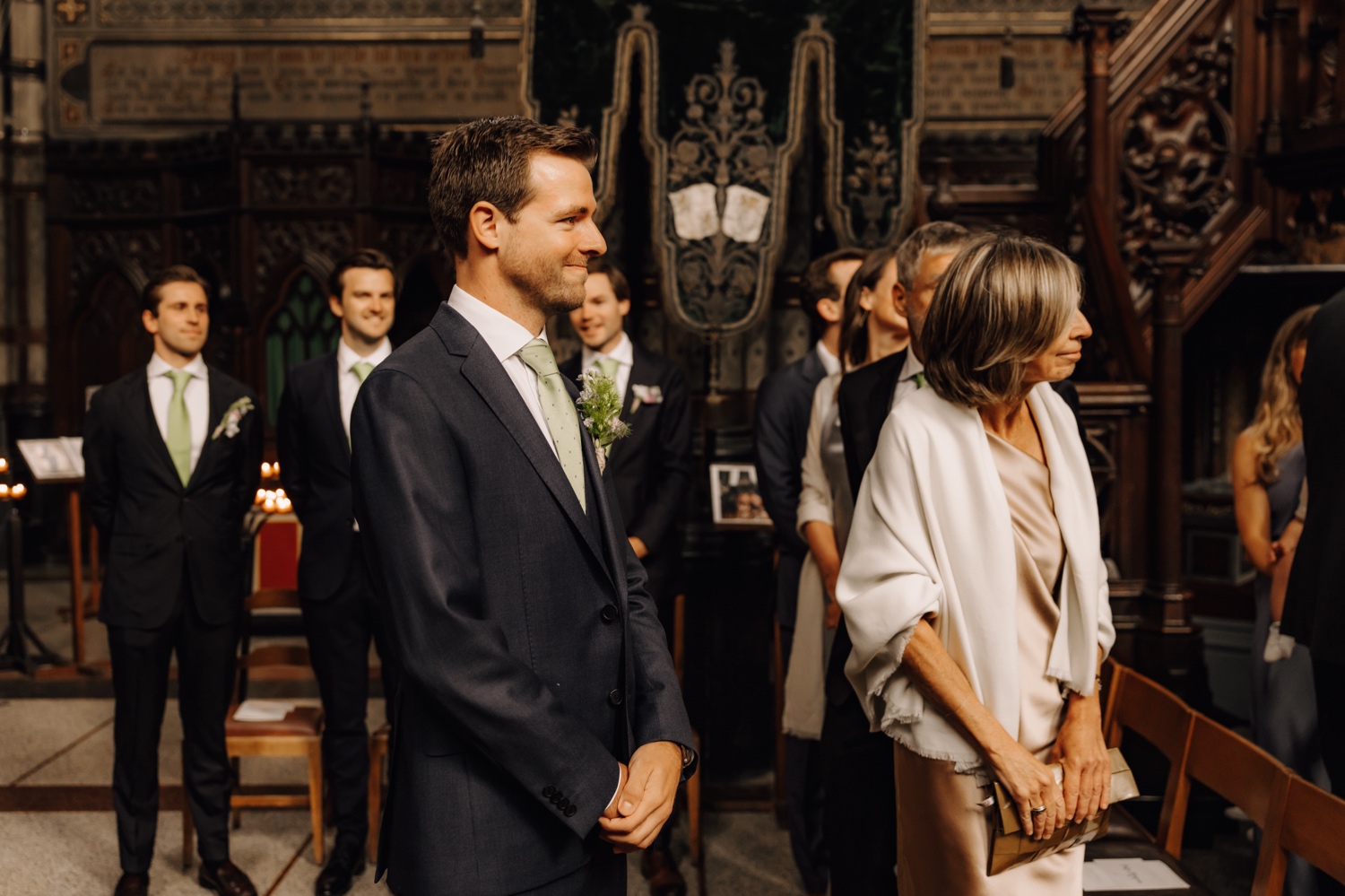 Een regenachtige huwelijksdag bij Hoeve Engelendael - bruidegom en zijn moeder kijken naar de bruid die de kerk binnenwandelt