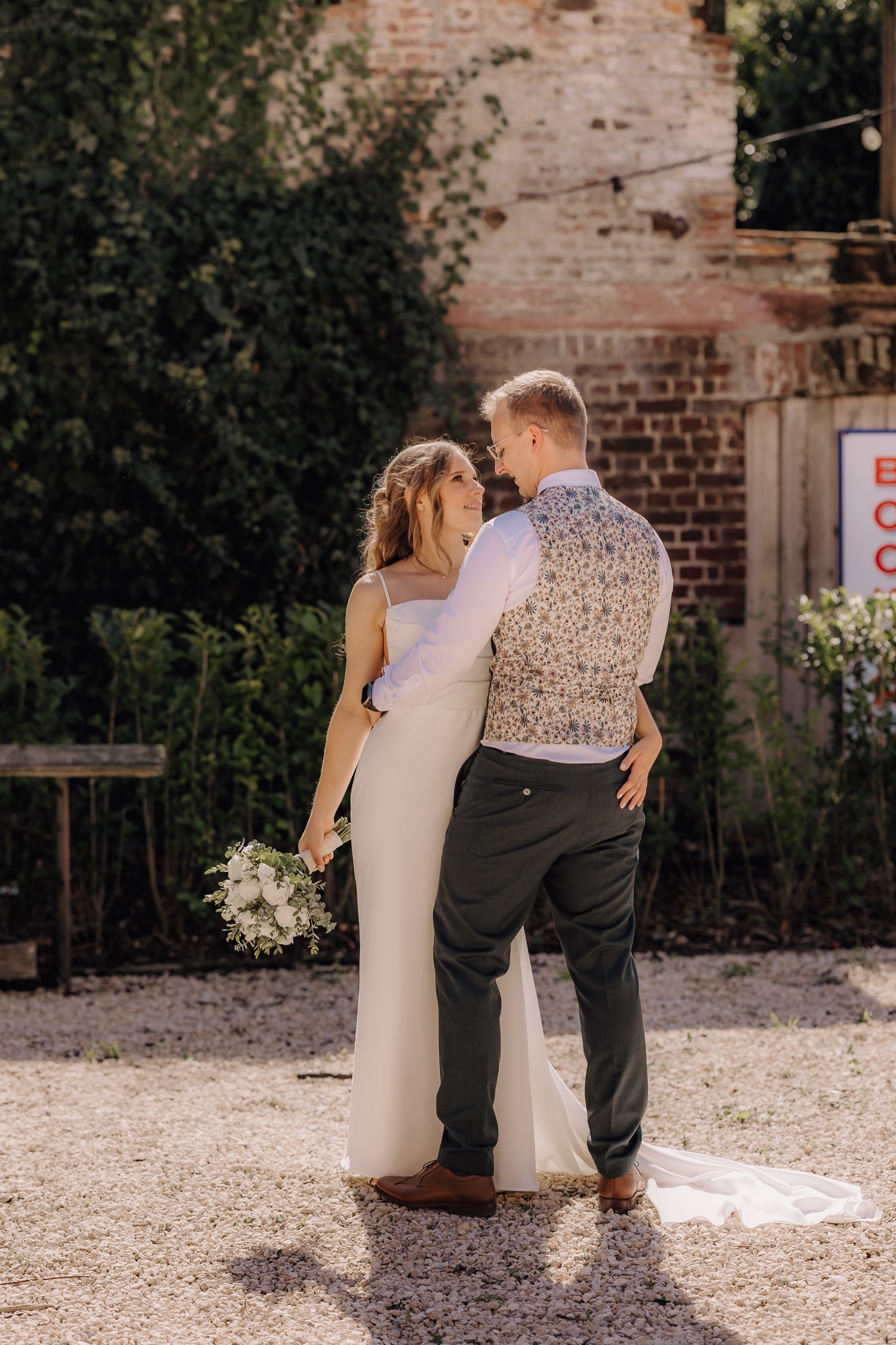 Landelijk huwelijk bij vierkantshoeve Bar Silo - bruidspaar kijkt elkaar in de ogen tijdens fotoshoot bij Bar Silo