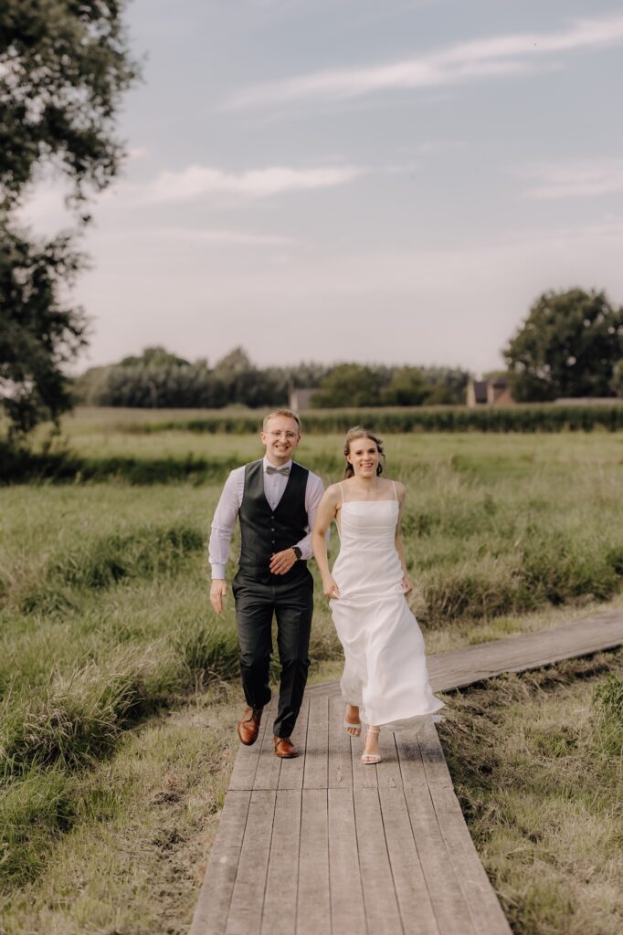 bruidspaar loopt over houten vlonderpad door de tuin van Bar Silo