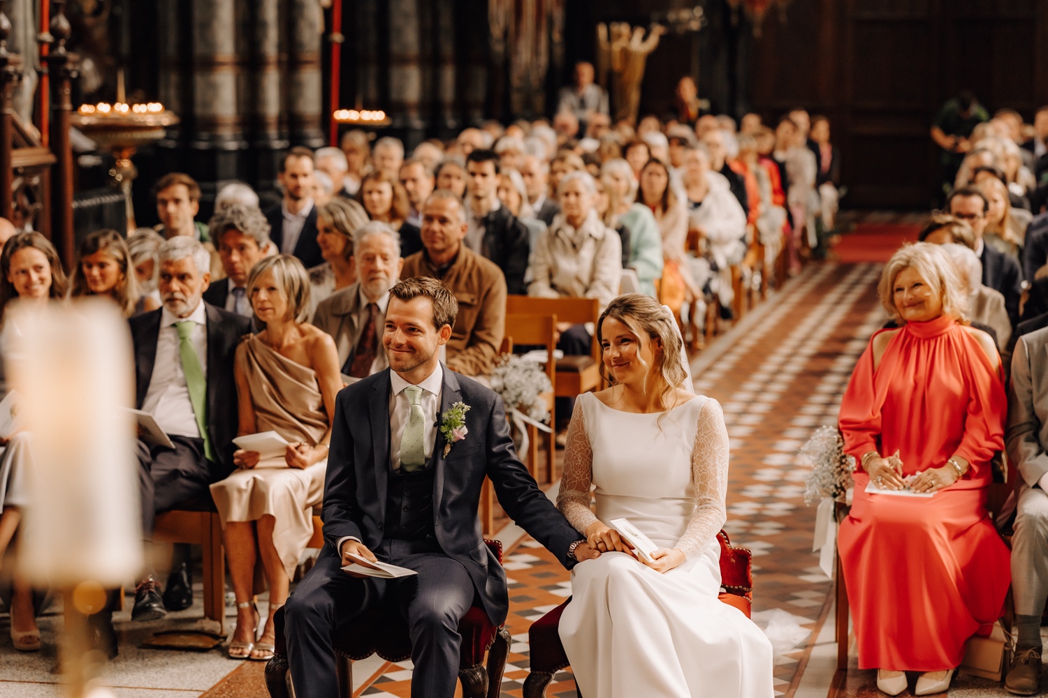 Een regenachtige huwelijksdag bij Hoeve Engelendael - bruidspaar kijkt naar zangeres in de kerk