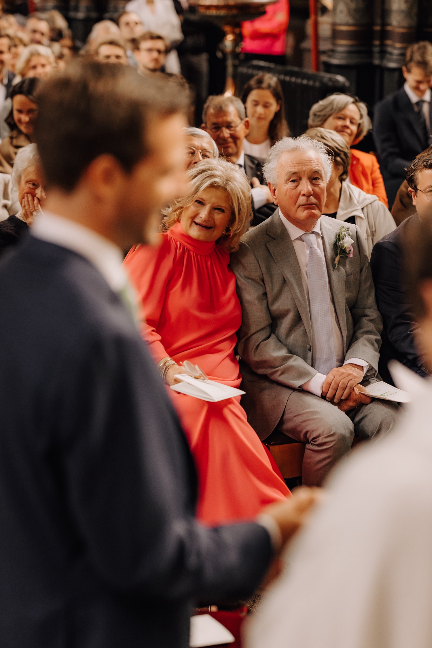 Een regenachtige huwelijksdag bij Hoeve Engelendael - ouders bruid kijken emotioneel naar hun dochter tijdens geloften