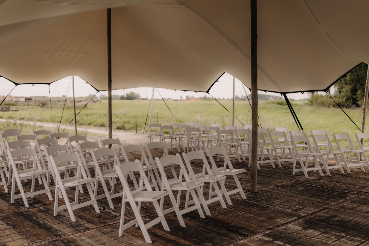 Landelijk huwelijk bij vierkantshoeve Bar Silo - detailfoto van de ceremonieopstelling onder de tent bij Bar Silo