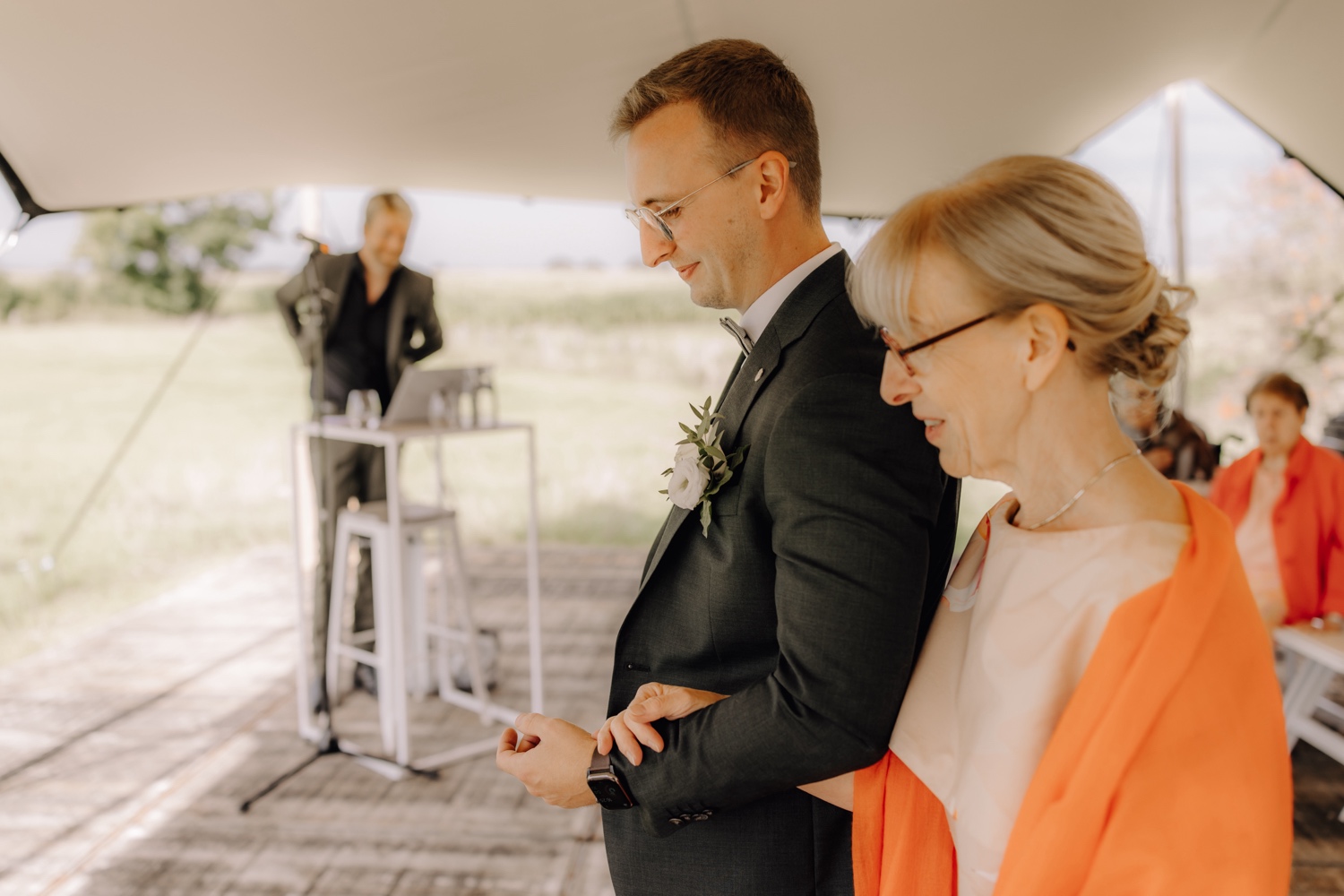 Landelijk huwelijk bij vierkantshoeve Bar Silo - Bruidegom en zijn moeder wandelen door het gangpad van de ceremonie