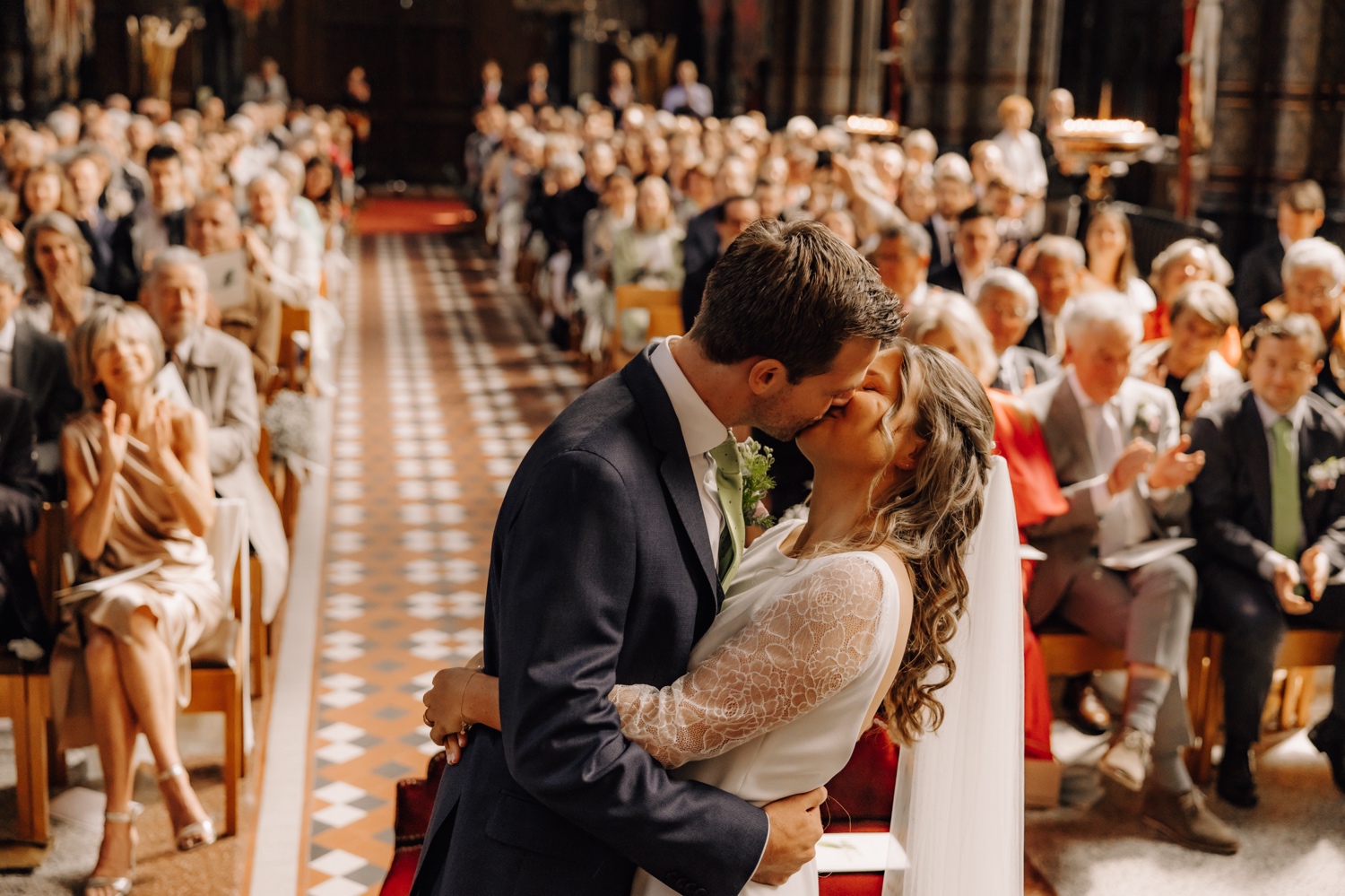 Een regenachtige huwelijksdag bij Hoeve Engelendael - bruid en bruidegom kussen elkaar in de kerk