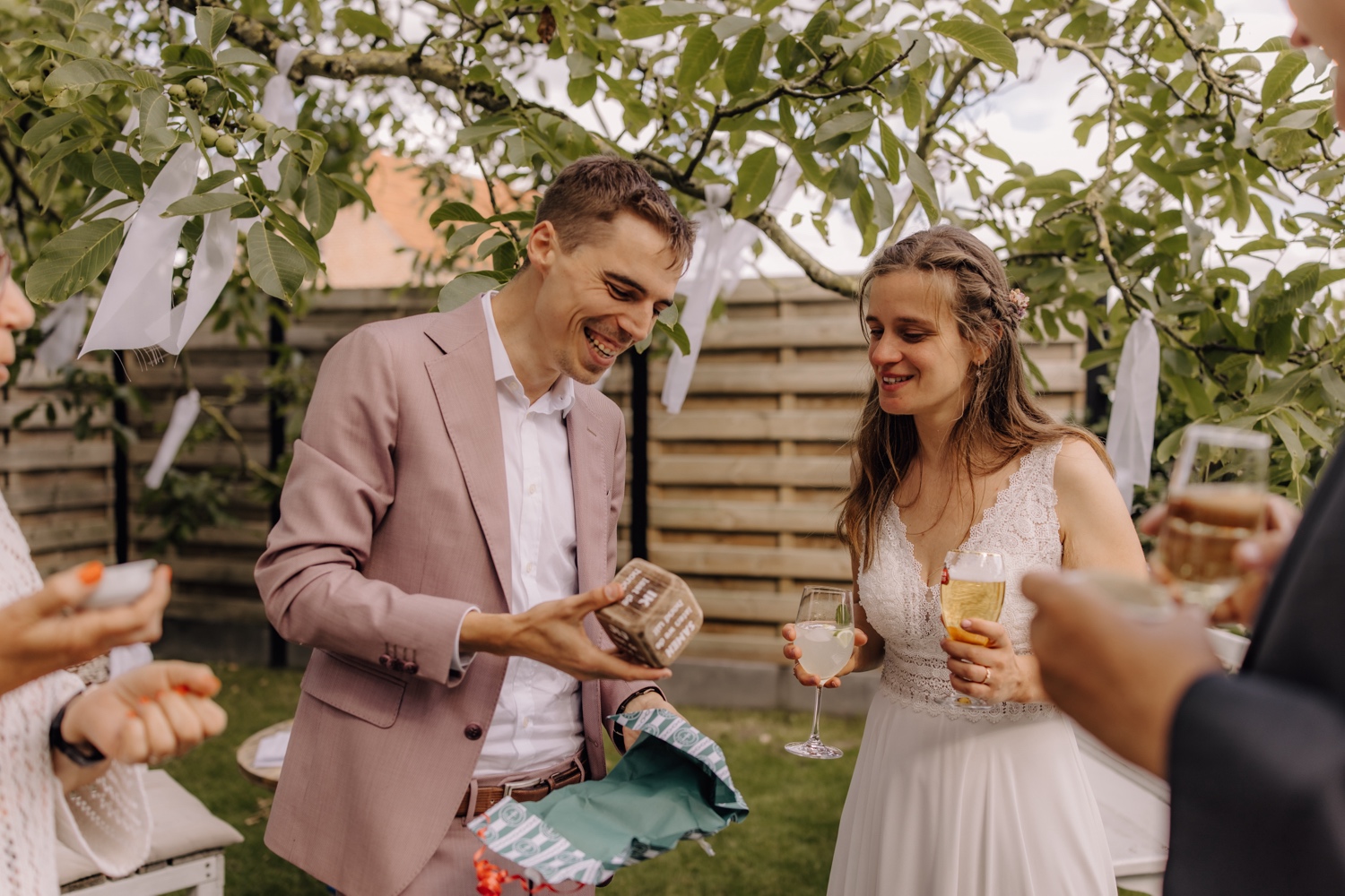 Een intiem huwelijk met twee honden en modderige laarzen - bruidspaar geniet van hun receptie in de tuin