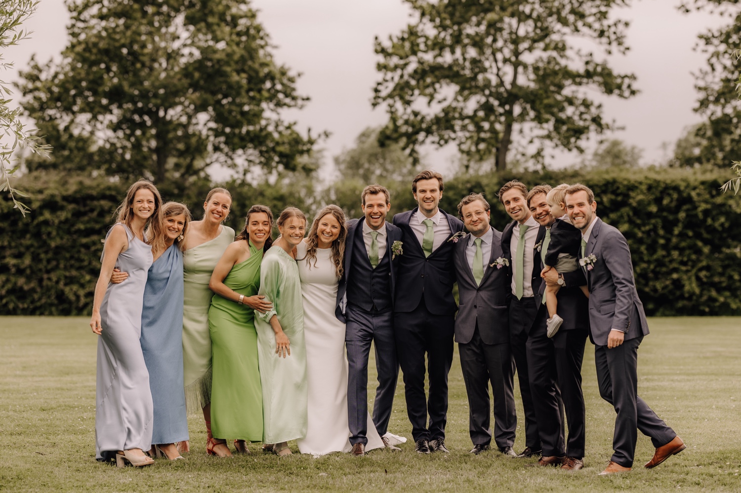 Een regenachtige huwelijksdag bij Hoeve Engelendael - bruidspaar poseert met hun familie