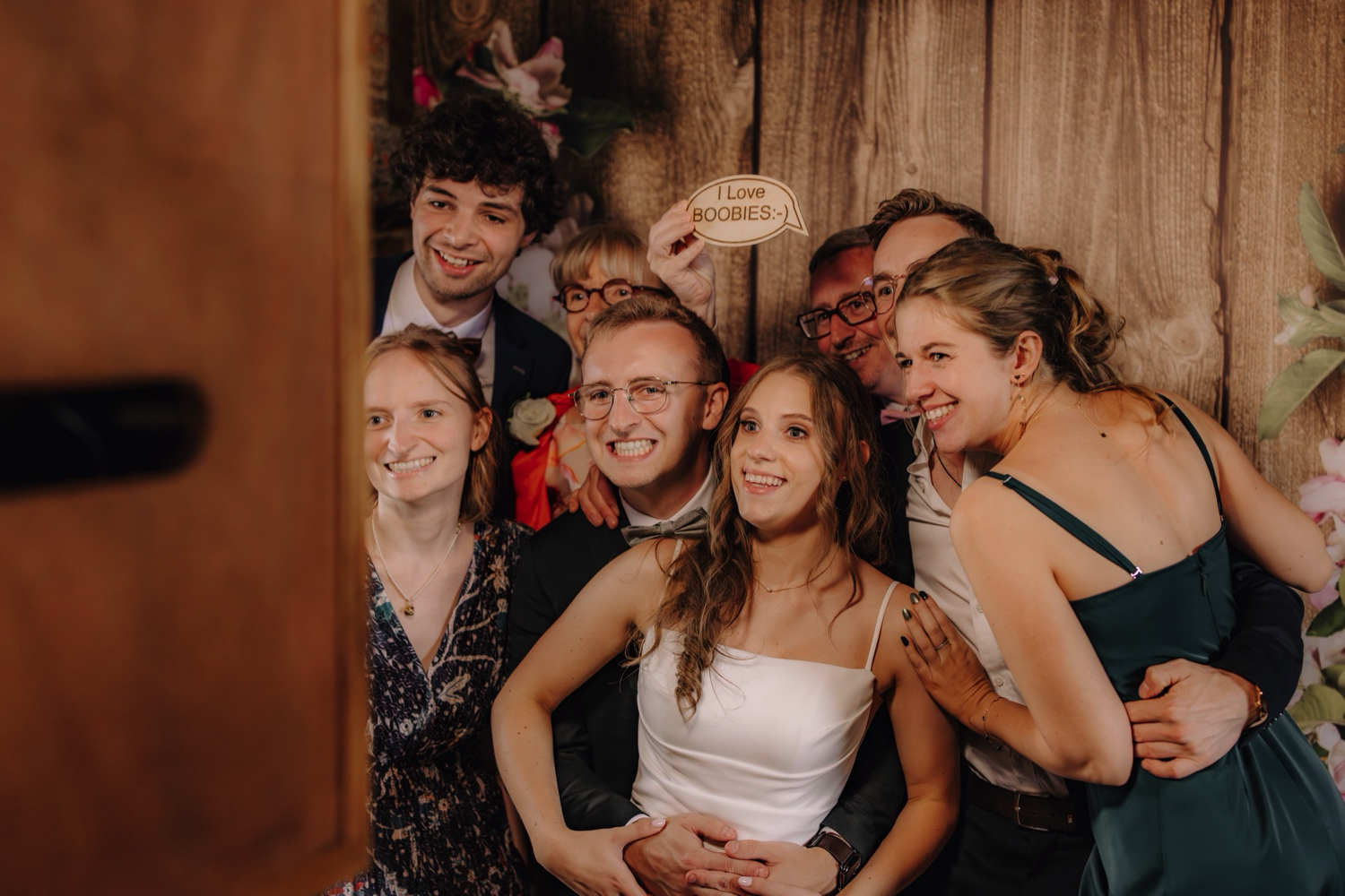 Landelijk huwelijk bij vierkantshoeve Bar Silo - bruidspaar poseert met familie voor Photo Booth