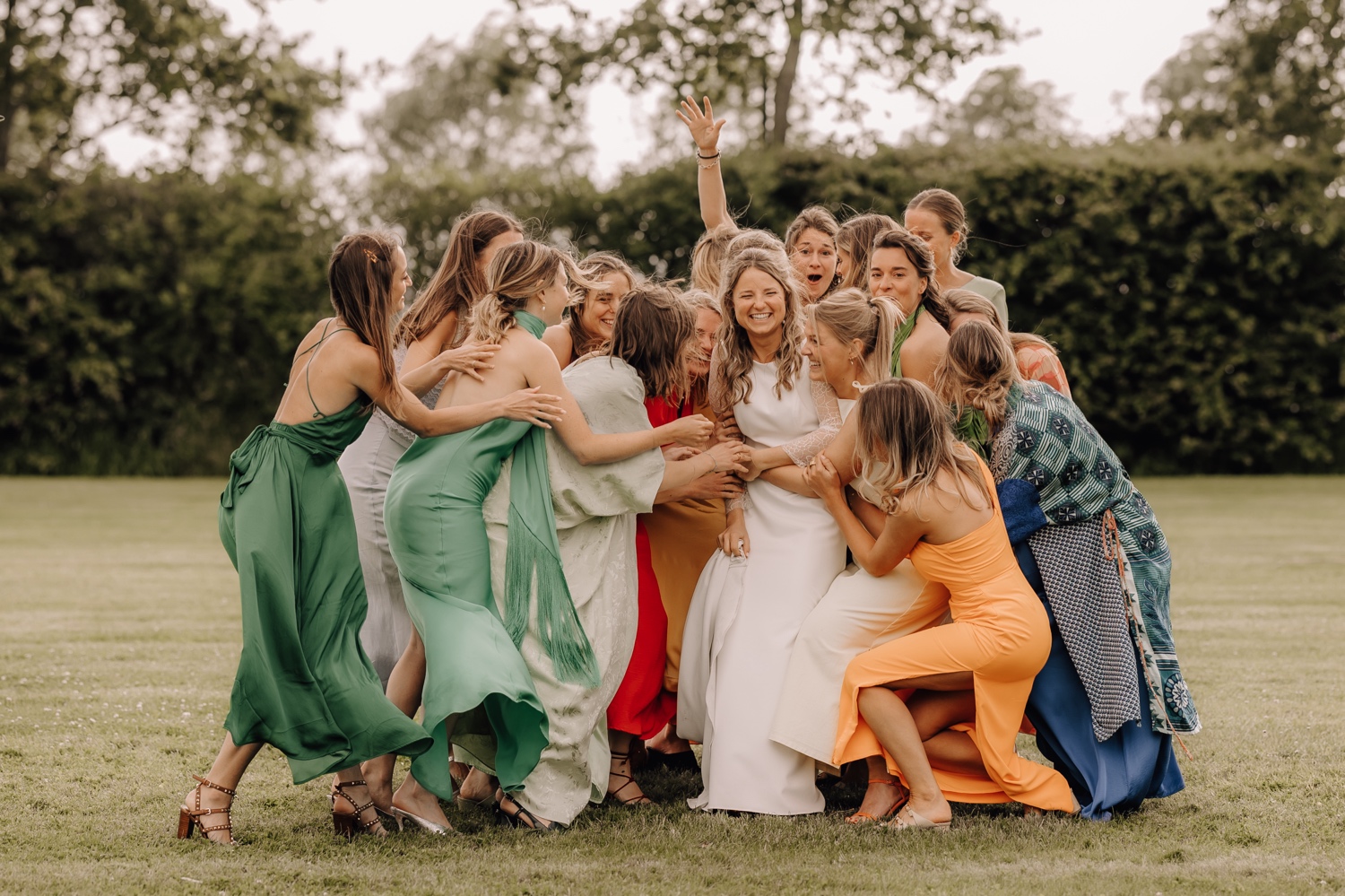 Een regenachtige huwelijksdag bij Hoeve Engelendael - bruid wordt geplet door haar bruidsmeisjes tijdens fotoshoot