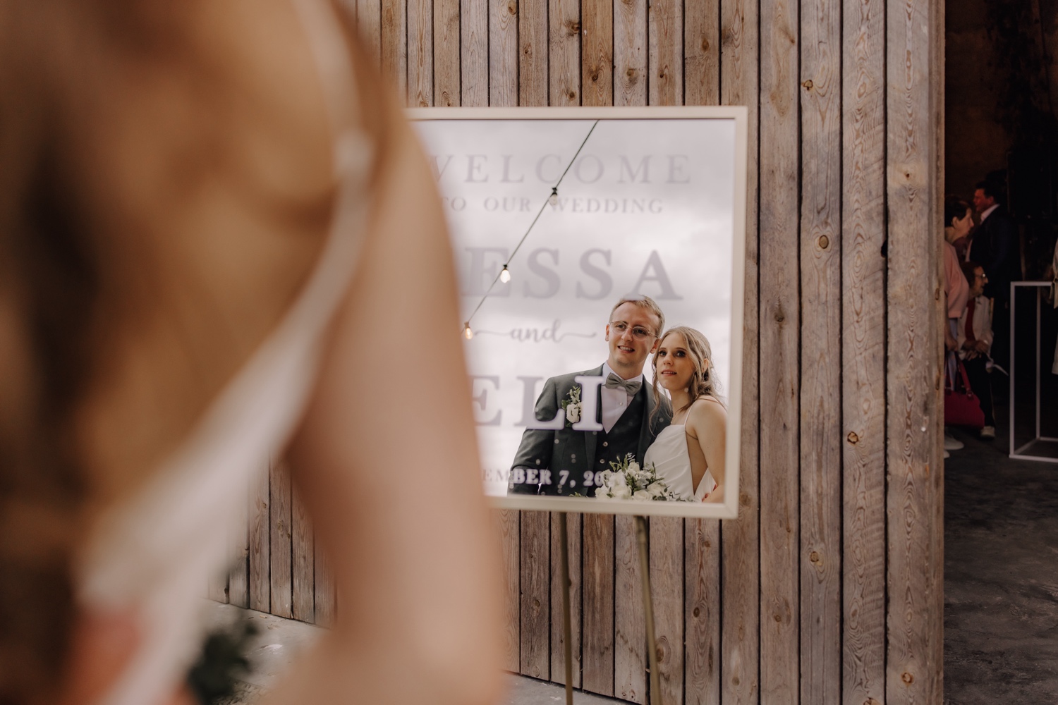 Landelijk huwelijk bij vierkantshoeve Bar Silo - foto van de reflectie van het bruidspaar in het welkomstbord