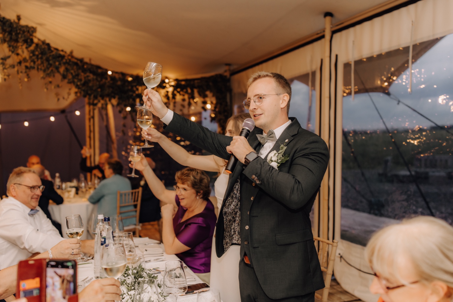 Landelijk huwelijk bij vierkantshoeve Bar Silo - bruidspaar klinkt op het moment tijdens diner