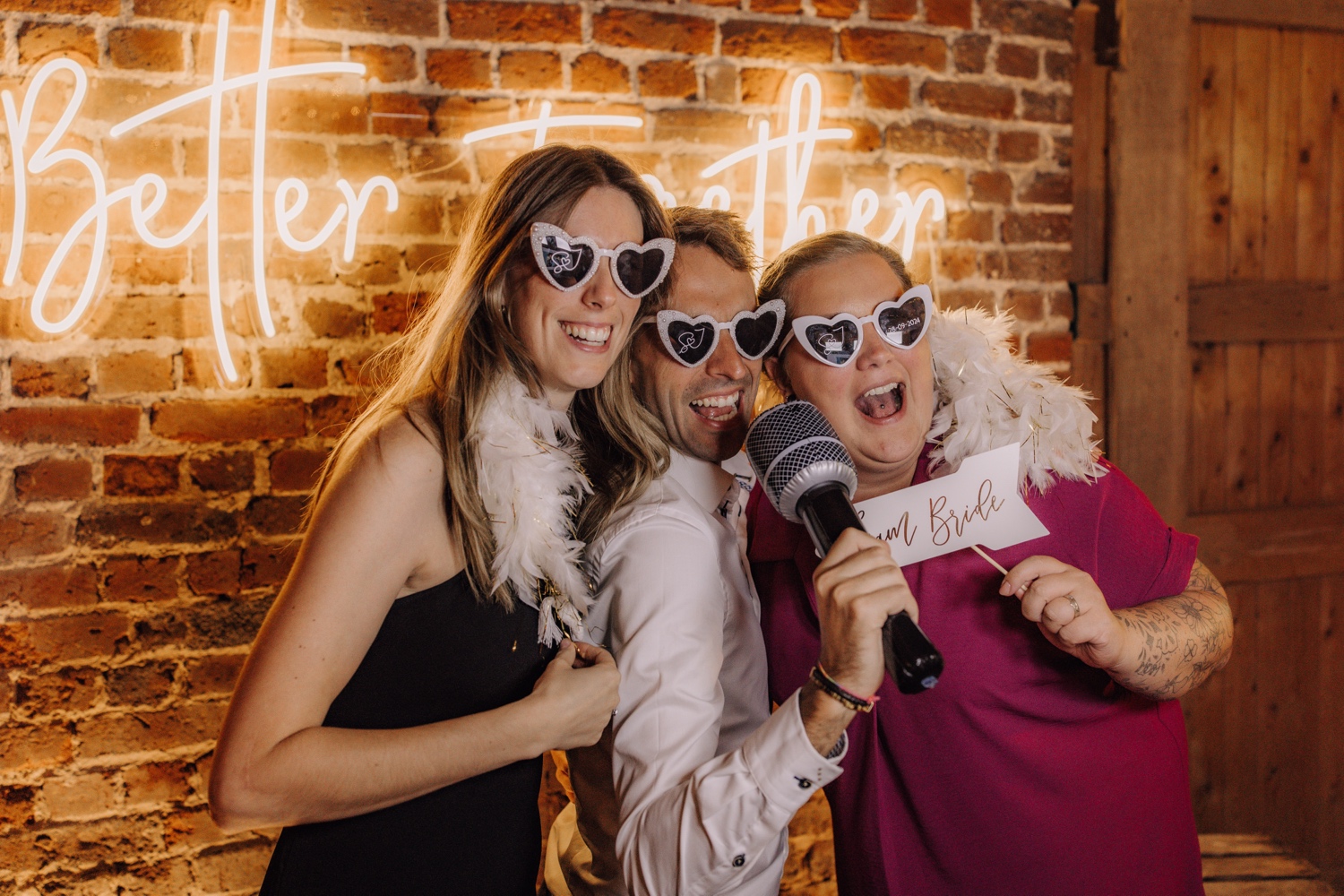 Landelijk huwelijk bij Ferme Koer - gasten poseren met brillen en slierten voor de Photo Booth