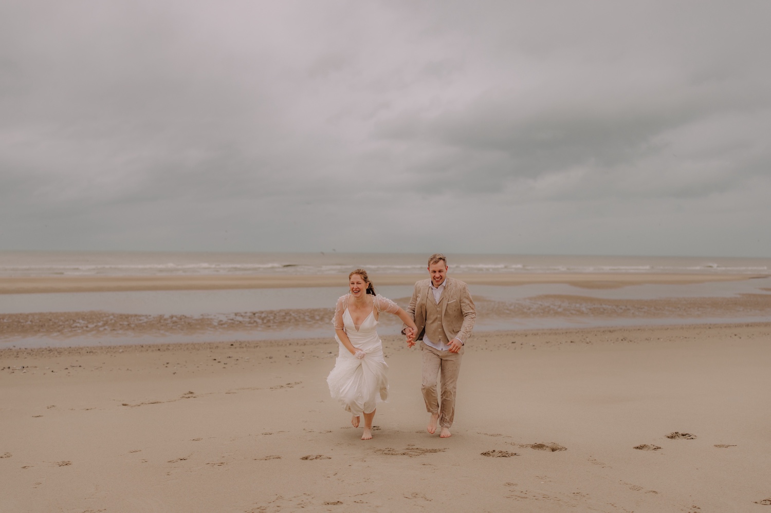 Huwelijksfotoshoot in Escalles Frankrijk al lopend op het strand